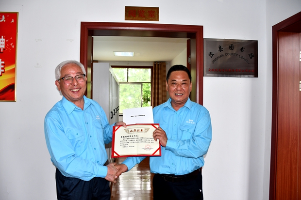 公司工會主席許鋒（右）向公司監(jiān)事會主席、捐書人胡夏生頒發(fā)《收藏證書》